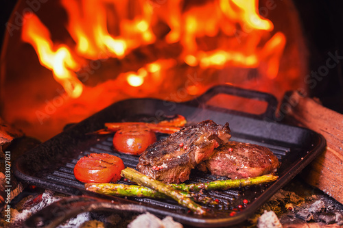  two steaks grilled on the background of fire