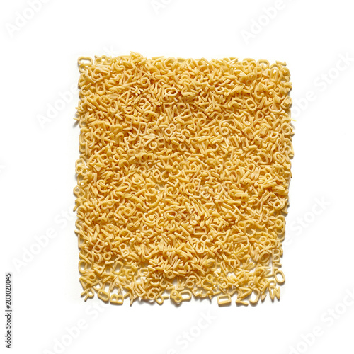 Alphabet macaroni letters shaped in the form of a square. Overhead view, isolated on white background