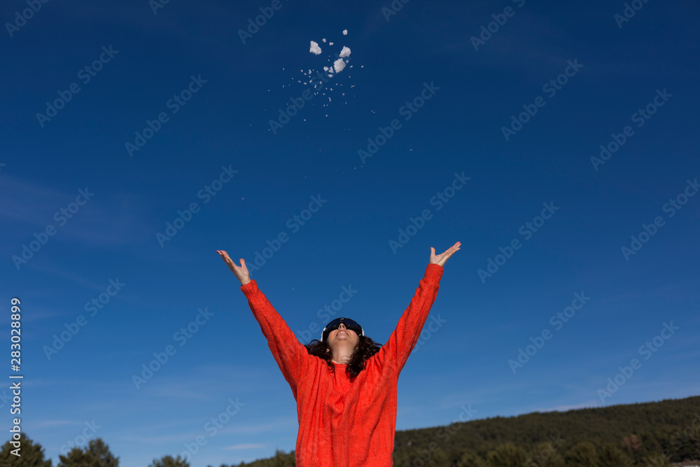 portrait of a young beautiful woman playing with the snow. Sunny weather. Wearing warm clothes. Winter lifestyle portrait of a young beautiful woman playing with the snow. Sunny weather. Wearing warm clothes. Winter lifestyle
