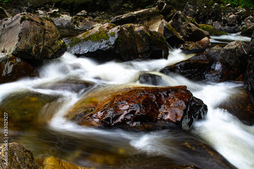 Water flow round a colorful rock.