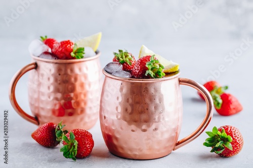 Photography Refreshing iced Moscow mule alcoholic cocktail in copper mugs with strawberry an