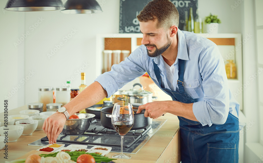 Smiling and confident chef standing in large kitchen Smiling and confident chef standing in large kitchen