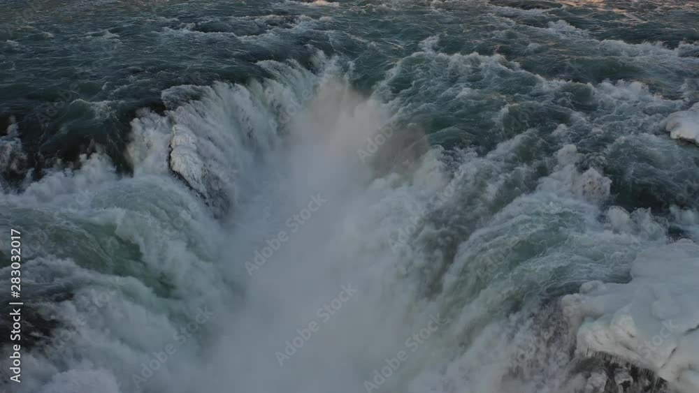 Tilting close-up drone shot of beautiful waterfall, natural landscapes in popular Iceland Tilting close-up drone shot of beautiful waterfall, natural landscapes in popular Iceland