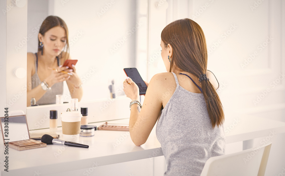 Amazing young woman doing her makeup in front of mirror. Portra Amazing young woman doing her makeup in front of mirror. Portra