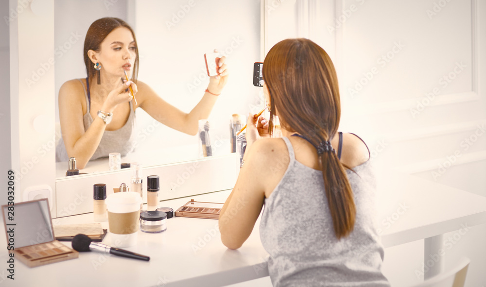Amazing young woman doing her makeup in front of mirror. Portra Amazing young woman doing her makeup in front of mirror. Portra