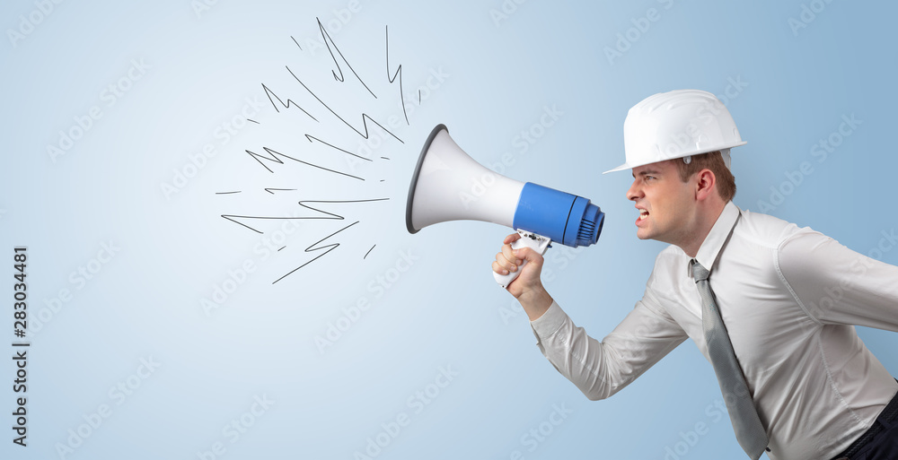 Young architect constructor yelling with megaphone and copyspace Young architect constructor yelling with megaphone and copyspace
