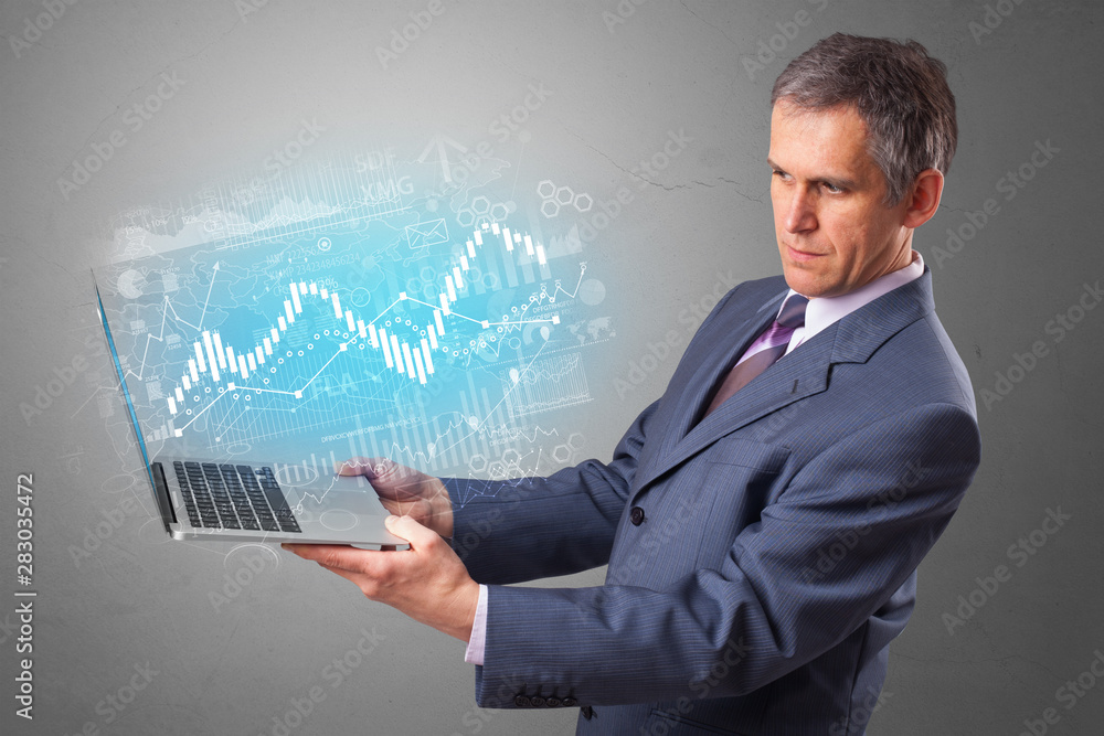 Man holding laptop projecting financial information, diagrams and charts Man holding laptop projecting financial information, diagrams and charts