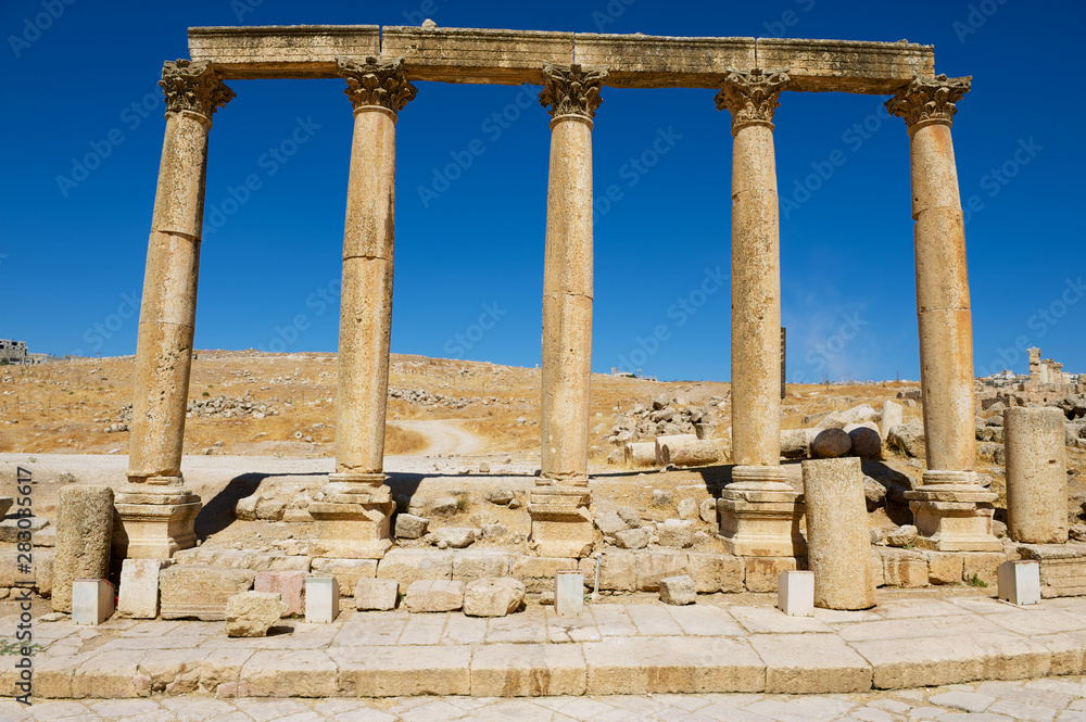 Corinthian Columns over the blue sky at the ruins of the Colonnade street in the ancient Roman city of Gerasa (modern Jerash) in Jordan.