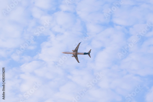 Passenger airplane flying in blue sky. Plane in sky with clouds and copy space. 