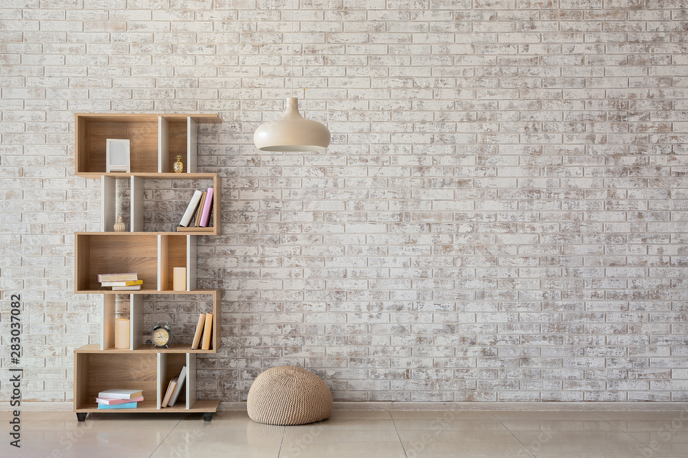 Interior of modern room with bookcase, pouf and lamp - obrazy, fototapety, plakaty 