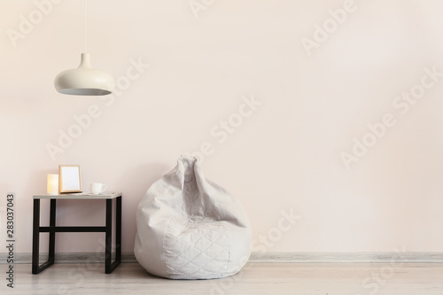 Fototapeta Naklejka Na Ścianę i Meble -  Interior of modern room with bean bag chair, table and lamp