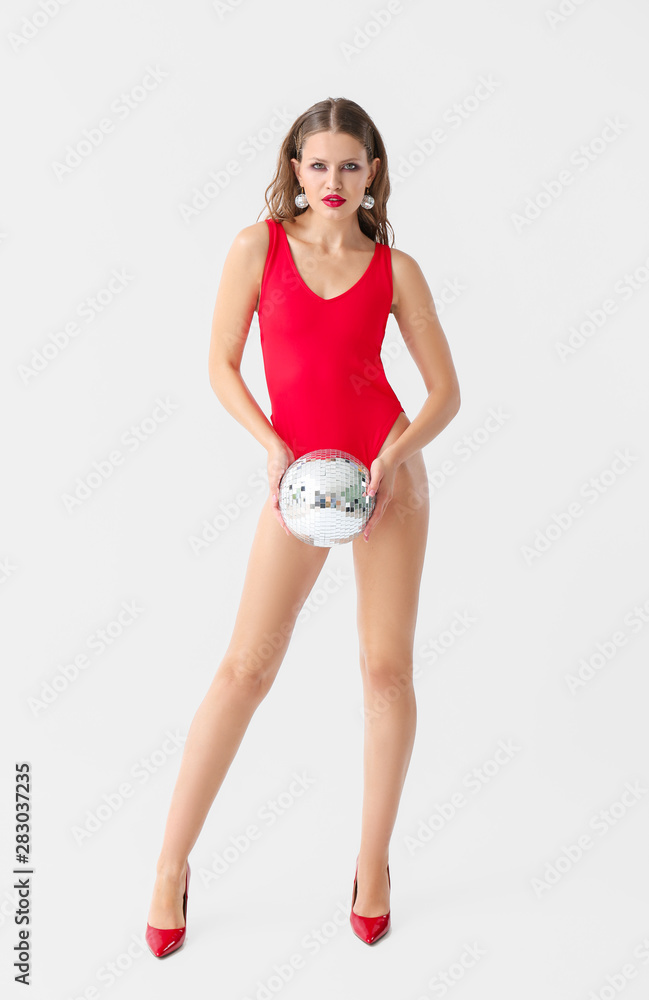 Fashionable young woman with disco ball on white background Fashionable young woman with disco ball on white background