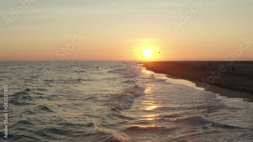 Sunset footage over the mediterranean sea withd kids playing.  Flying at a low altitude at Espiguette beach, port camargue photo