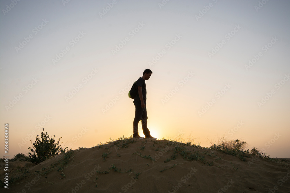 Man on sand dune, Thar Desert in Jaisalmer, Rajasthan State, India Man on sand dune, Thar Desert in Jaisalmer, Rajasthan State, India