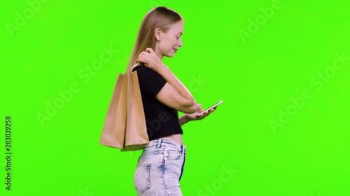 Using an app or texting while walking by a beautiful young model over green screen.
