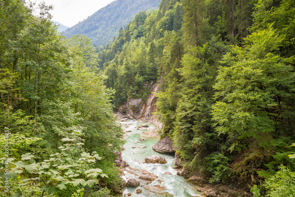 Fototapeta premium Scenic view of a river with emerald or turquoise colored water in a valley in Tirol, Austria