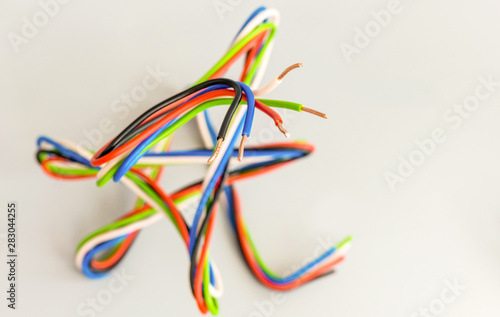 Electric wires of different colors in curved form on a gray background