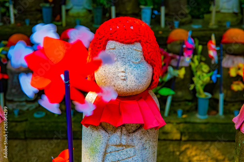 Statue guardian wearing red hat in Tokyo daytime photo