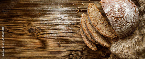 Bread,  traditional spelled sourdough bread cut into slices on a rustic wooden background, close-up, top view, copy space. Concept of traditional leavened bread baking methods