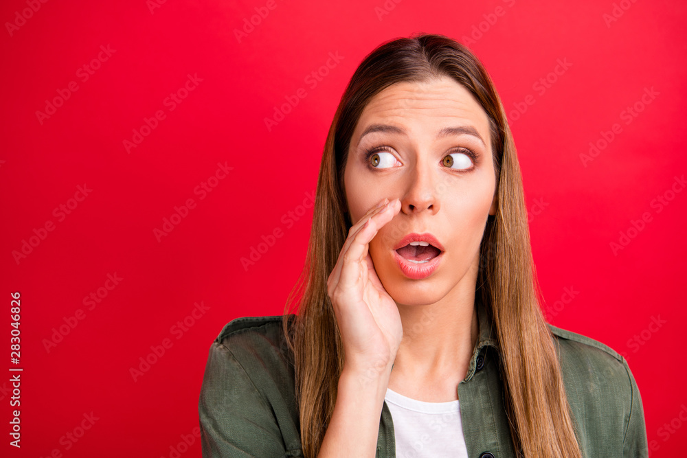 Photo of girlfriend whispering you some information other people should not know while isolated with red background Photo of girlfriend whispering you some information other people should not know while isolated with red background