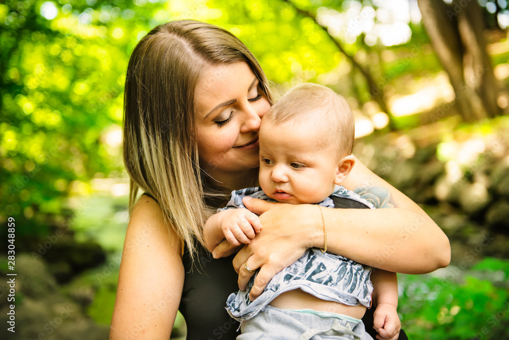 Happy mother having fun with his baby son on the park Happy mother having fun with his baby son on the park
