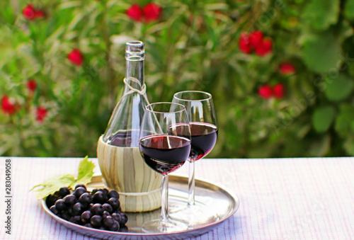 Schilderij op canvas red wine for two on a patio table