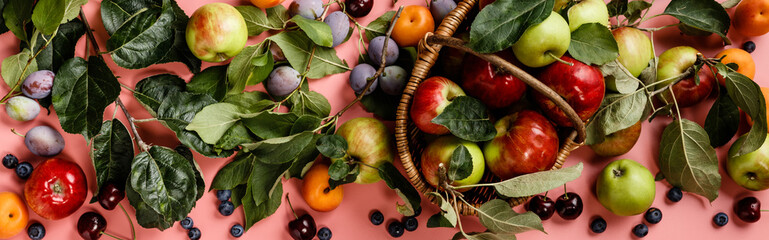 Flat-lay of fresh fruits and berries on pink background
