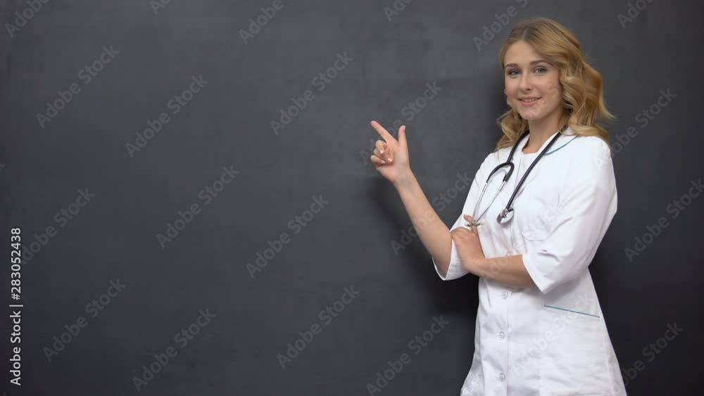 Female doctor pointing at place on blackboard, template for medical prescription Female doctor pointing at place on blackboard, template for medical prescription