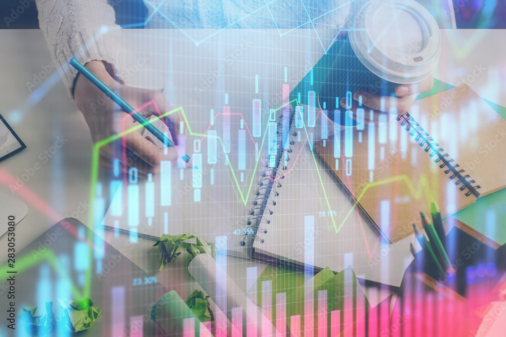 Financial forex graph displayed on hands taking notes background. Concept of research. Multi exposure Financial forex graph displayed on hands taking notes background. Concept of research. Multi exposure