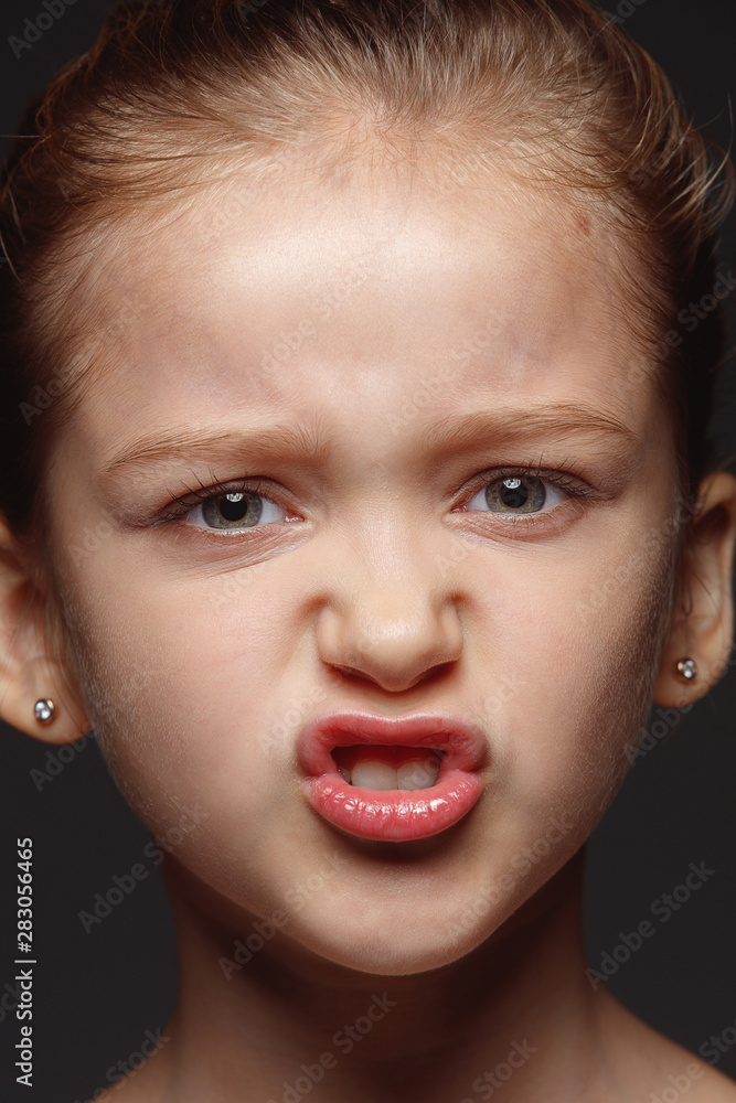 Close up portrait of little and emotional caucasian girl. Highly detail photoshot of female model with well-kept skin and bright facial expression. Concept of human emotions. Angry, agressive. Close up portrait of little and emotional caucasian girl. Highly detail photoshot of female model with well-kept skin and bright facial expression. Concept of human emotions. Angry, agressive.