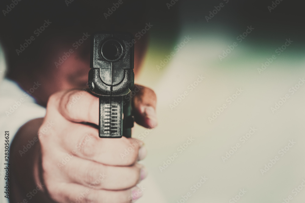 Man shooting gun, man pointing gun to camera, close-up image Man shooting gun, man pointing gun to camera, close-up image