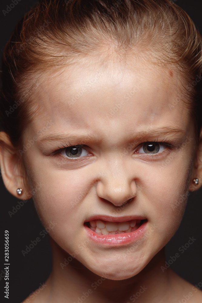 Close up portrait of little and emotional caucasian girl. Highly detail photoshot of female model with well-kept skin and bright facial expression. Concept of human emotions. Angry, agressive. Close up portrait of little and emotional caucasian girl. Highly detail photoshot of female model with well-kept skin and bright facial expression. Concept of human emotions. Angry, agressive.