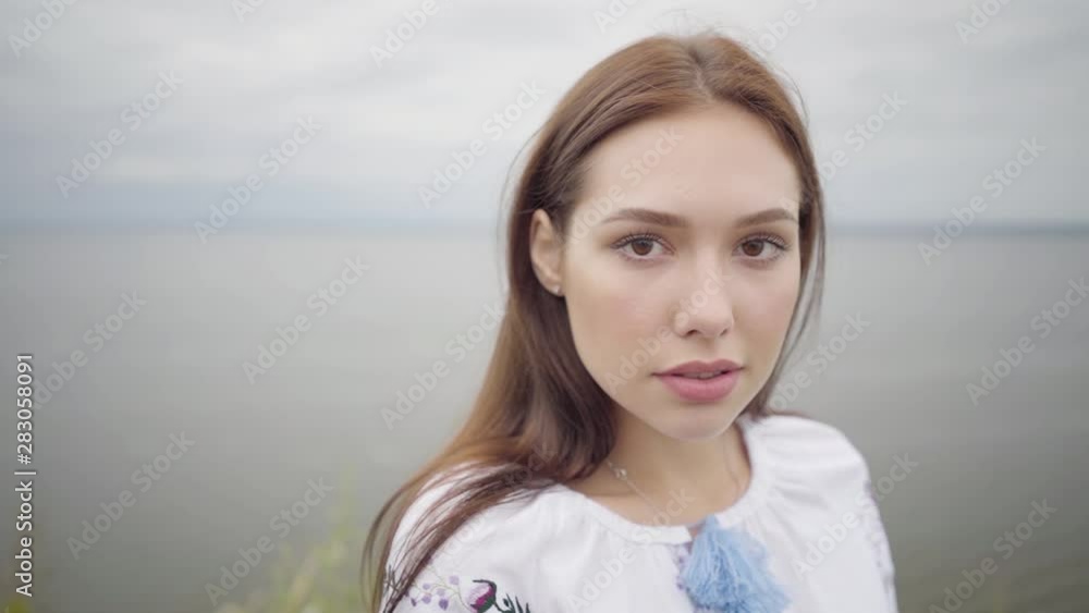 Portrait charming carefree girl wearing long summer fashion dress looking confident at camera enjoying stands on the field. Leisure and weekend of a pretty young woman outdoors. Real people series. Portrait charming carefree girl wearing long summer fashion dress looking confident at camera enjoying stands on the field. Leisure and weekend of a pretty young woman outdoors. Real people series.