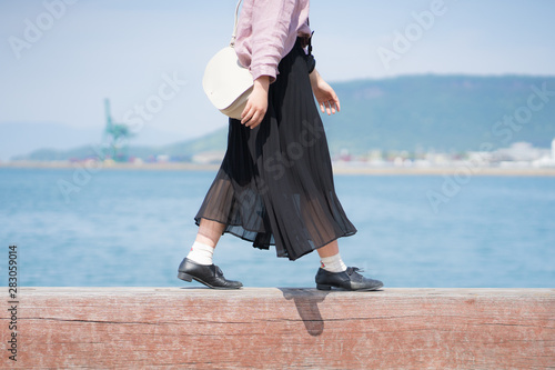 黒いスカートを履いて歩く女性 旅行