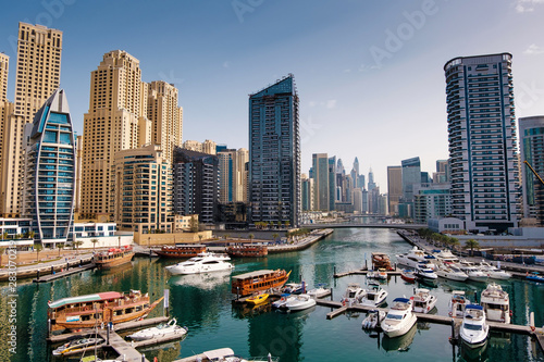 Photography Dubai marina with boats and buildings with gates, United Arab Emirates