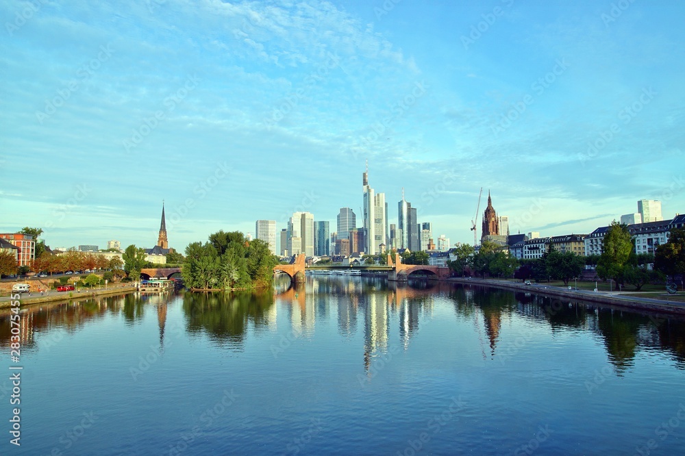 Frankfurt Skyline reflecting in the Main River on sunrise. european city skyline and financial centre of Frankfurt. Germany Skyscraper buildings on blue sky background. Business and finance concept