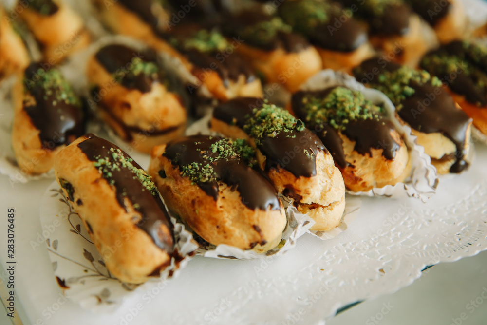 Traditional sweet french eclair or profiterole desserts on the table. Traditional sweet french eclair or profiterole desserts on the table.