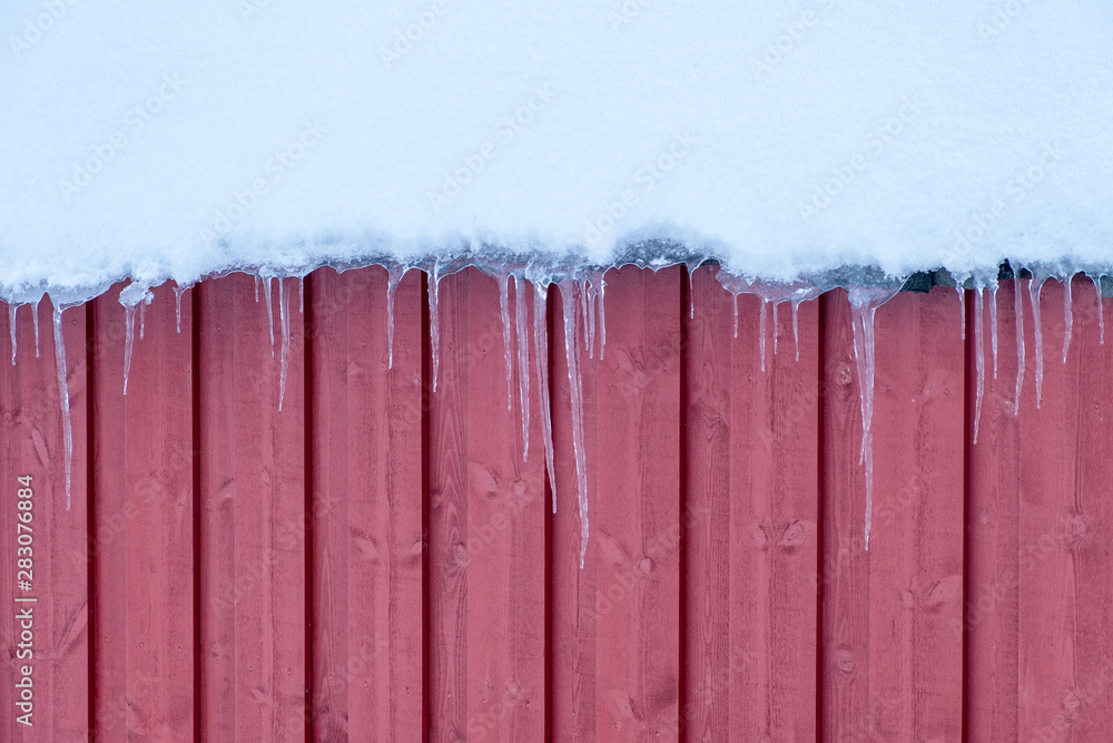 Icicles frost hanging on wooden snowy roof in winter Icicles frost hanging on wooden snowy roof in winter