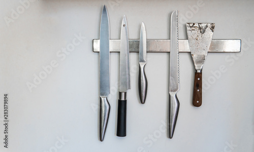 Magnetic wall installed knives holder for modern kitchen.
