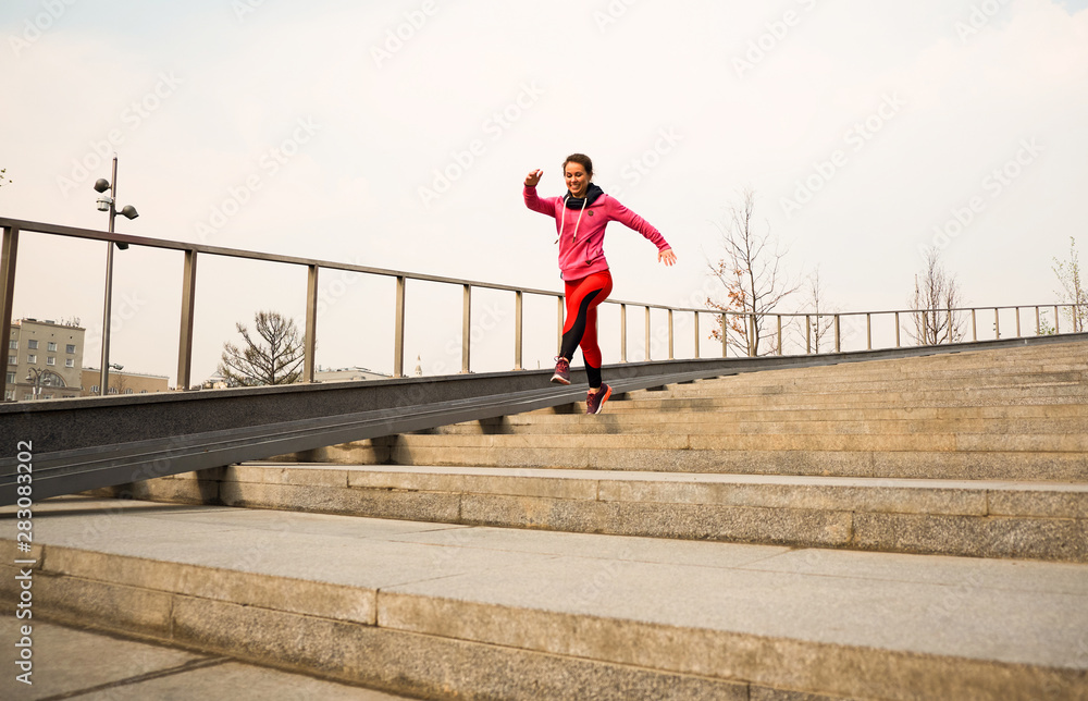 healthy lifestyle sports woman running up on stone stairs at sunrise seaside