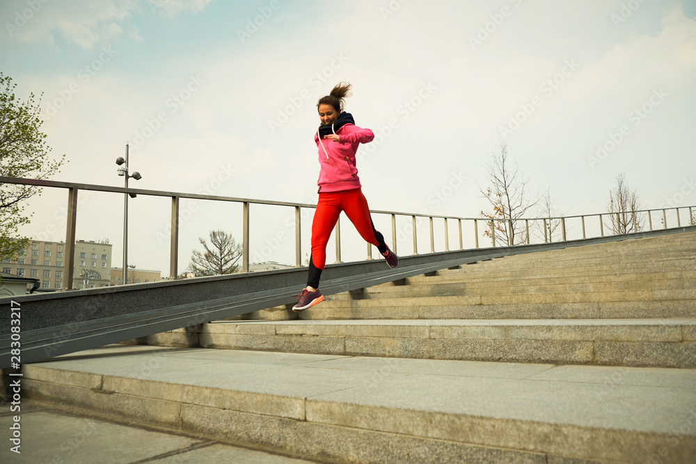 healthy lifestyle sports woman running up on stone stairs at sunrise seaside