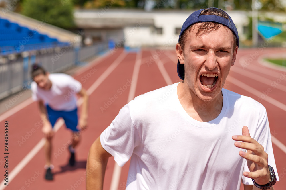 Young athlete man racing on running track with the opponent Young athlete man racing on running track with the opponent