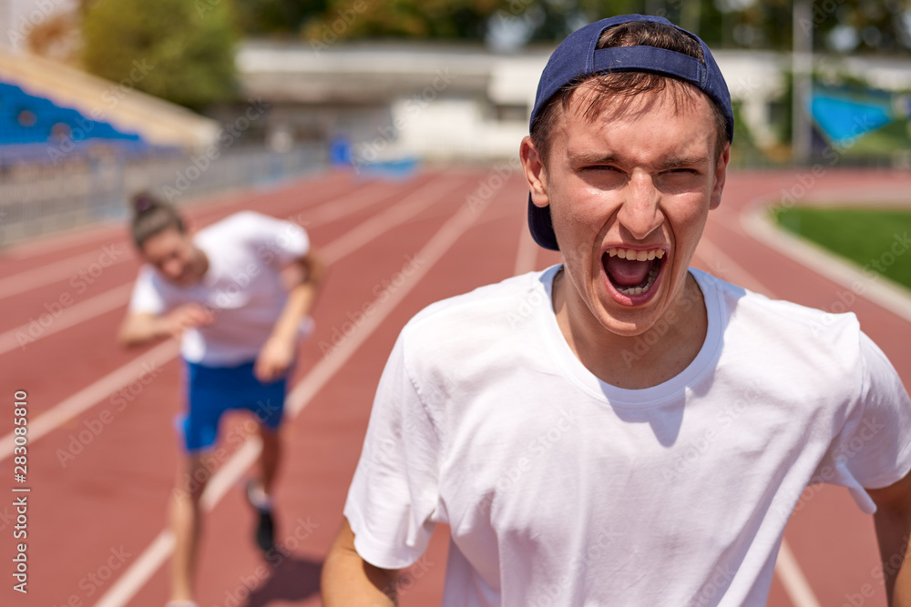 Young athlete man racing on running track with the opponent Young athlete man racing on running track with the opponent