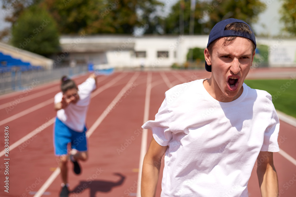 Young athlete man racing on running track with the opponent Young athlete man racing on running track with the opponent