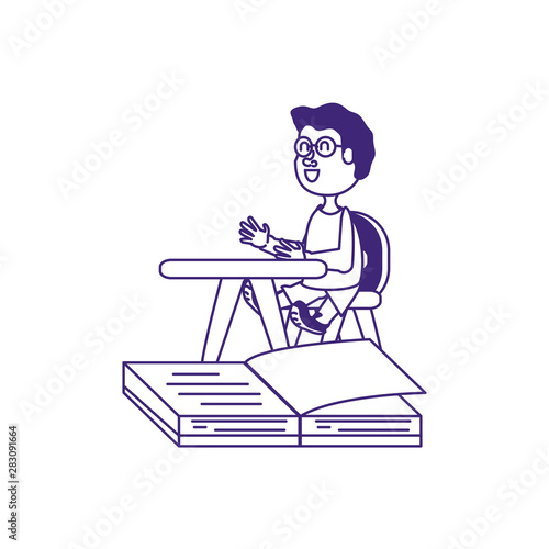 cute little student boy in desk with book open