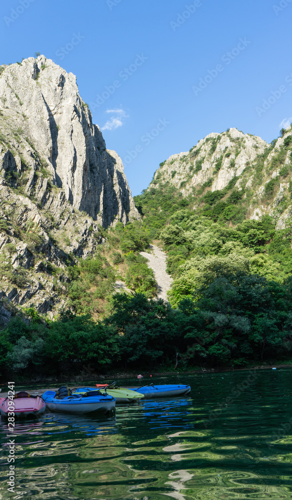 Colorful Canoes in Matka Canyon, Macedonia with no person. Kayaks in a pier and sunset in the mountains and lake