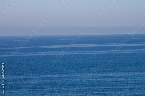 Current in the sea, top view. Shades of blue in the sea at the coastal current. Sea and sky, fifty shades of blue.