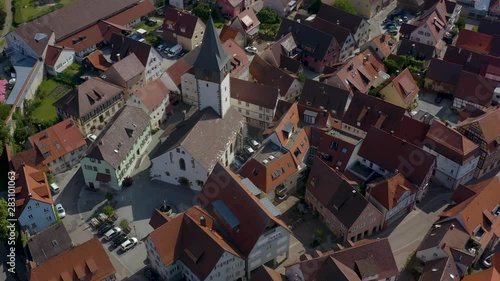 Aerial view from the old part of the city Niedernhall in Germany.  Low angle shot over Laurentius Church. Camera rotates right. photo