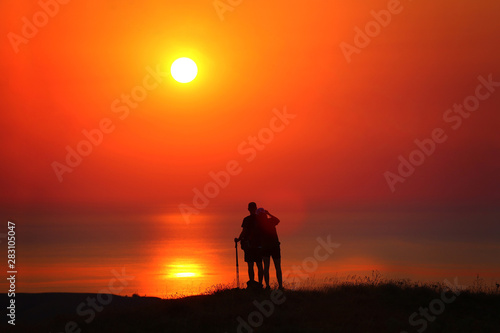 Silhouettes of a guy and a girl at sunrise by the sea photograph