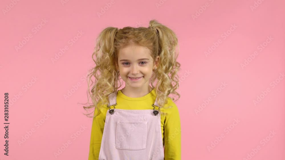 Funny curly little girl laugh in studio on pink background Funny curly little girl laugh in studio on pink background